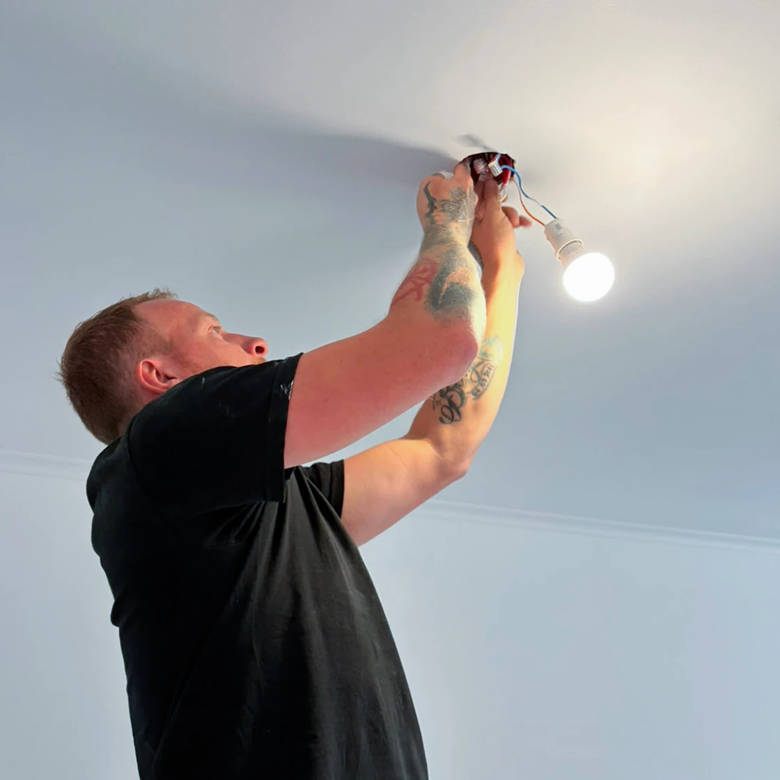 Électricien de chez Charnet raccordant un point lumineux au plafond, installation d'éclairage à Vichy dans l'Allier (03)